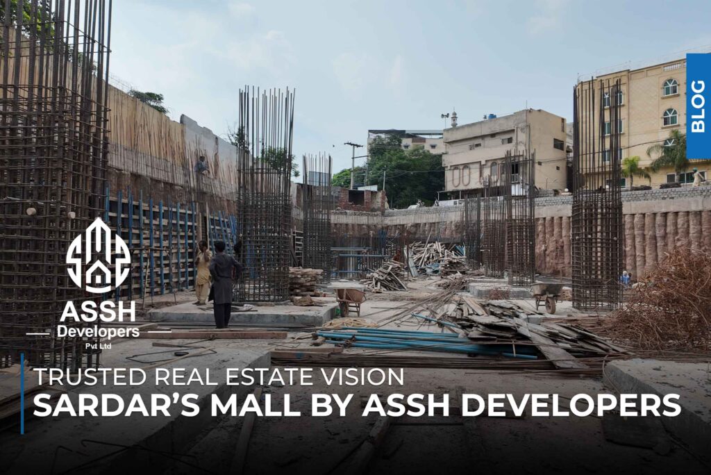 Construction site of Sardar’s Mall by ASSH Developers Pvt Ltd, showing reinforced steel framework, building materials, and workers on-site, with the text 'Trusted Real Estate Vision – Sardar’s Mall by ASSH Developers' overlayed at the bottom.